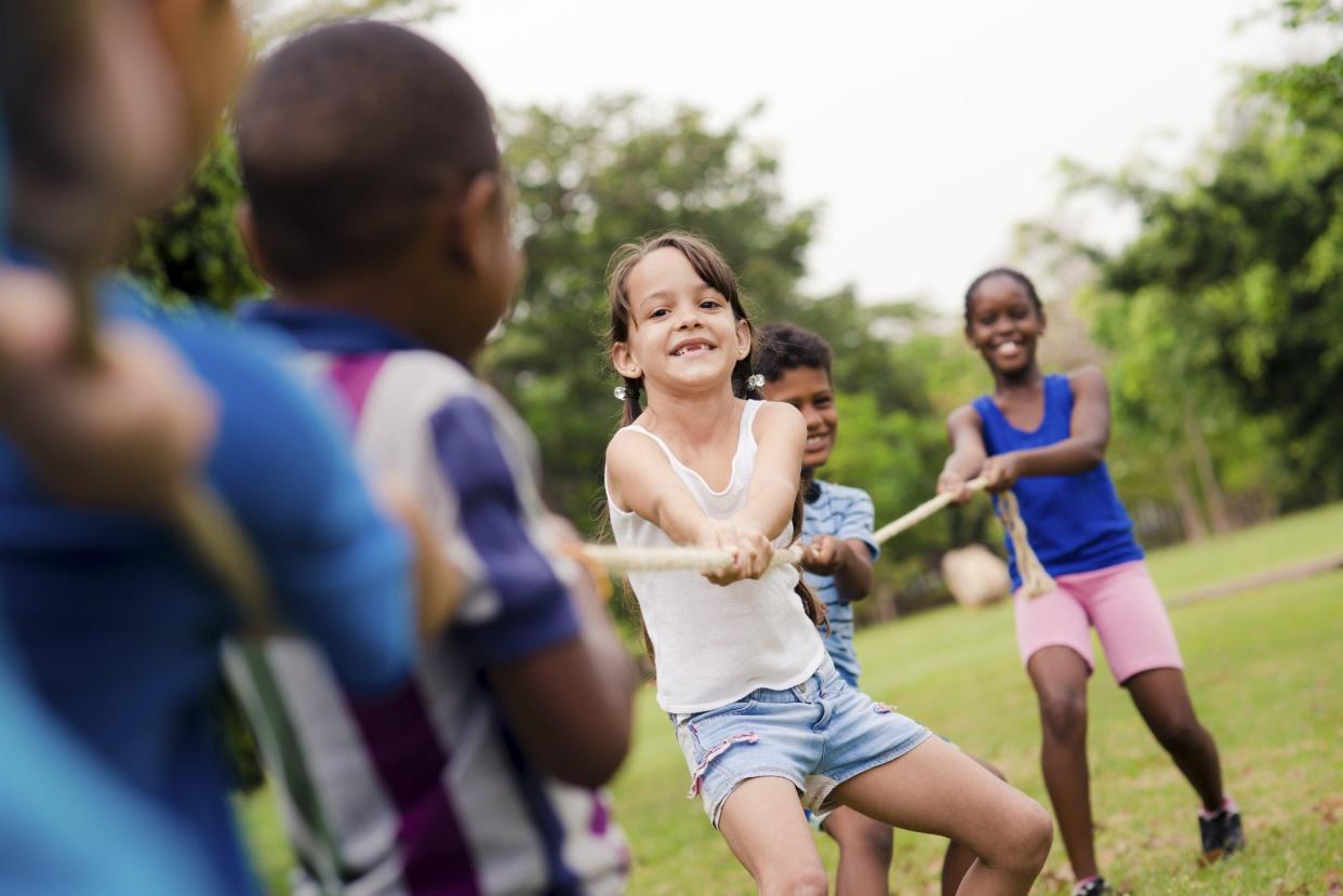 Tug-of-war and other outdoor activities, like sports, are part of the summer camp experience and help build teamwork skills.