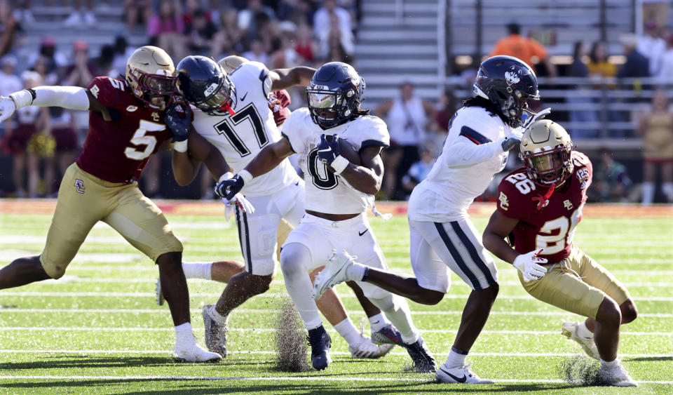 UConn running back Camryn Edwards (0) carries the bal during the second half of an NCAA college football game against Boston College Saturday, Oct. 28, 2023 in Boston. (AP Photo/Mark Stockwell)