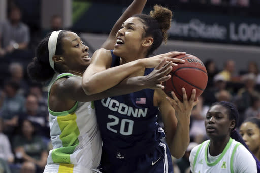 FILE - This Feb.16, 2020, file photo shows South Florida's Shae Leverett, left, and Connecticut's Olivia Nelson-Ododa during the first half of an NCAA college basketball game in Tampa, Fla. UConn, one of the original members of the Big East Conference, is hoping a return to the league will help put the Huskies back among the elite programs in college basketball. The Huskies spent seven years in the American Athletic Conference, on a mostly downward trajectory since winning a fourth national title in 2014. (AP Photo/Mike Carlson, File)