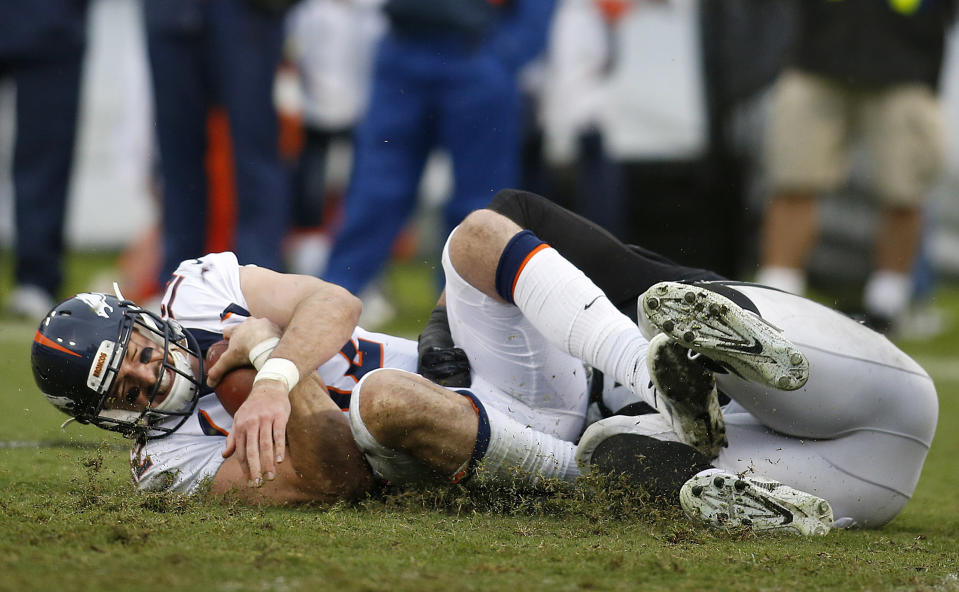 Denver Broncos quarterback Paxton Lynch, left, is sacked by the Raiders. (AP)