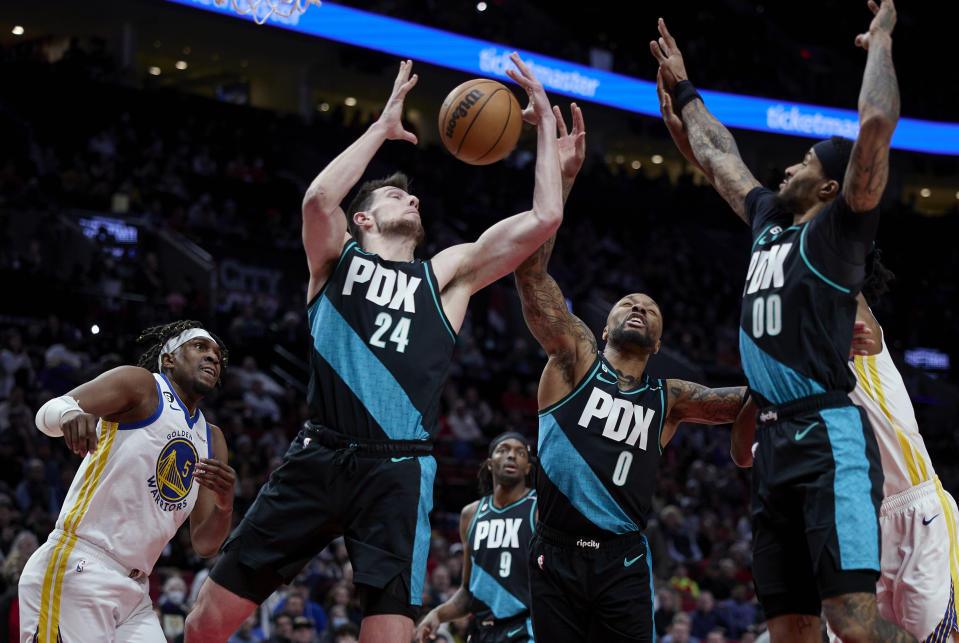 Portland Trail Blazers forward Drew Eubanks (24), guard Damian Lillard (0) and guard Gary Payton II (00) reach for a rebound in front of Golden State Warriors forward Kevon Looney during the first half of an NBA basketball game in Portland, Ore., Wednesday, Feb. 8, 2023. (AP Photo/Craig Mitchelldyer)