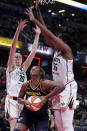 Indiana Fever forward Aliyah Boston (7) drives to the basket between New York Liberty forward Breanna Stewart, left, and forward Jonquel Jones, right, in the second half of a WNBA basketball game, Thursday, May 16, 2024, in Indianapolis. (AP Photo/Michael Conroy)