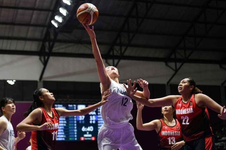 North Korean Ro Suk Yong (C), a member of the Unified Korea basketball team at the Asian Games, top-scored with 22 points, helping her team smash their hosts Indonesia