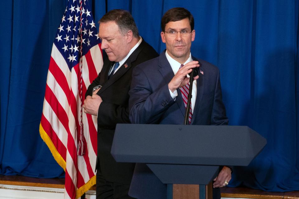 Secretary of State Mike Pompeo, left, hands off the microphone to Secretary of Defense Mark Esper to deliver a statement on Iraq and Syria, at President Donald Trump's Mar-a-Lago property, Sunday, Dec. 29, 2019, in Palm Beach, Fla.