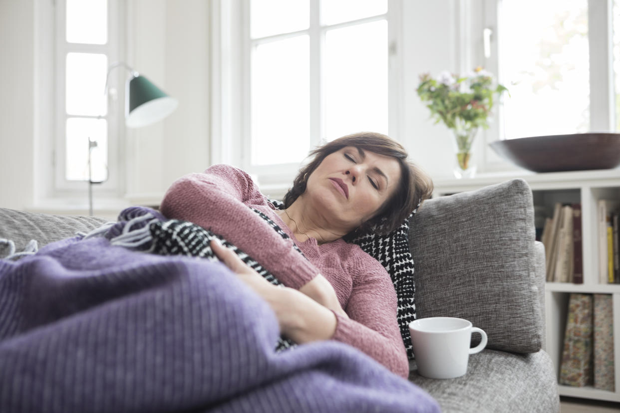 woman with period pain on couch