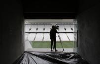 A journalist records a piece-to-camera at the construction site of the Arena de Sao Paulo Stadium, which will host the opening soccer match of the 2014 FIFA World Cup, in Sao Paulo April 15, 2014. Corinthians have taken formal control of the stadium that will host the opening match of this year's World Cup but officials said on Tuesday there is still a lot of work to do before the arena is ready to host big games. REUTERS/Nacho Doce (BRAZIL - Tags: SPORT SOCCER WORLD CUP BUSINESS CONSTRUCTION MEDIA)