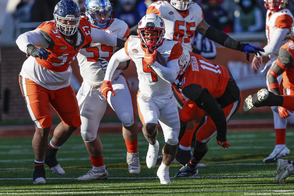 American Team running back TJ Pledger (4), of Utah, runs the ball 23 yards during the third quarter of an NCAA Senior Bowl college football game, Saturday, Feb. 5, 2022, in Mobile, Ala. (AP Photo/Butch Dill)