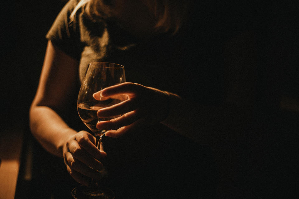 A woman is holding a glass of wine