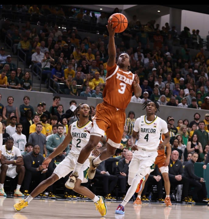 Texas guard Max Abmas scores between Baylor guard Jayden Nunn, left, and guard Ja’Kobe Walter, right, in the first half of an NCAA college basketball game, Monday, March 4, 2024, in Waco, Texas. (Rod Aydelotte/Waco Tribune-Herald via AP)