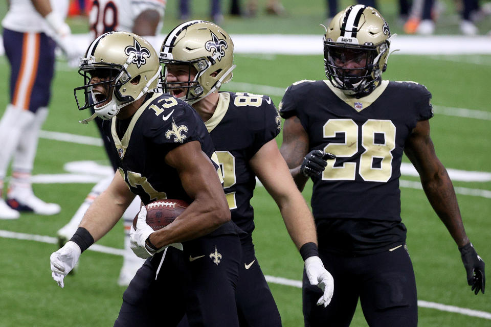 Michael Thomas #13, Adam Trautman #82 , and Latavius Murray #28 of the New Orleans Saints celebrate following Thomas' 11-yard touchdown during the first quarter against the Chicago Bears in the NFC Wild Card Playoff game at Mercedes Benz Superdome on January 10, 2021 in New Orleans, Louisiana. (Photo by Chris Graythen/Getty Images)