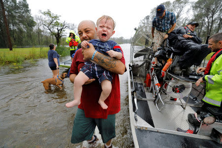 Oliver Kelly, 1 year old, cries as he is carried off the sheriff's airboat during his rescue from rising flood waters in the aftermath of Hurricane Florence in Leland, North Carolina, U.S., September 16, 2018. REUTERS/Jonathan Drake