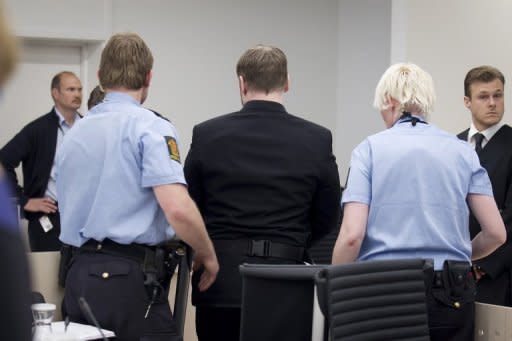 Norwegian killer Anders Behring Breivik (centre) is escorted out of court by police in Oslo. Proceedings were briefly halted when a family member of one of Breivik's victims threw a shoe at him, screaming "you killer, go to Hell!"