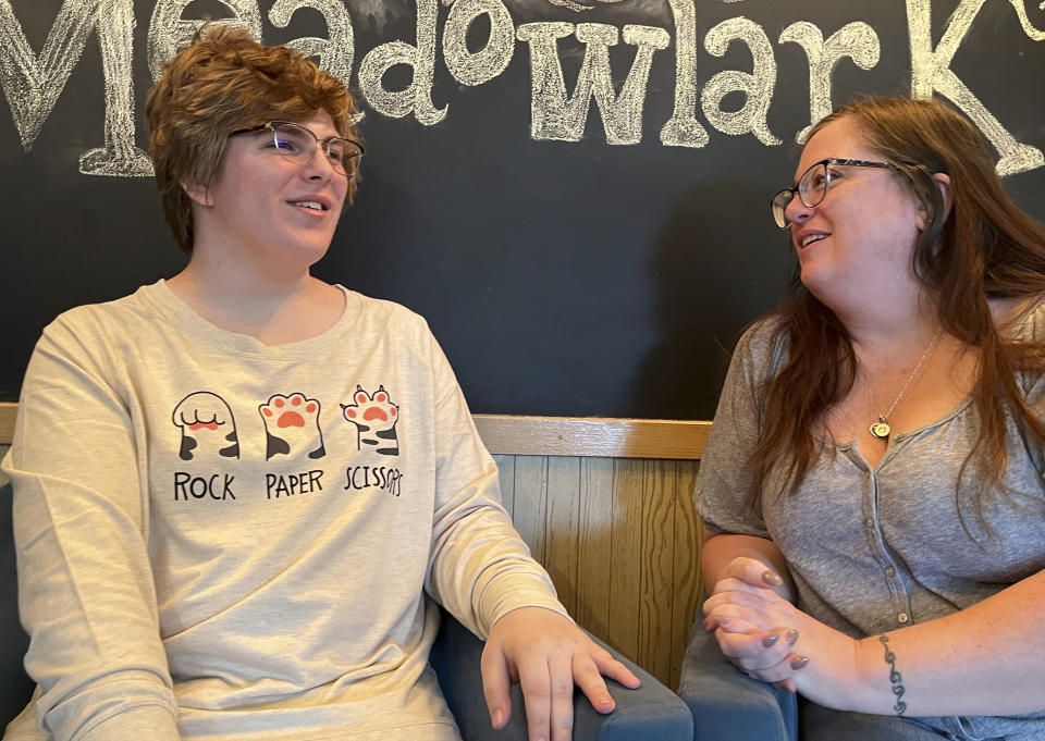 Nola Rhea, 17, left, and her mother, Heather Rhea, 47, sit together in a coffee shop on Sept. 26, 2023, in Lincoln, Neb., as they discuss Nola's plans to leave the state of Nebraska next year to attend college following the state's enactment of a law restricting gender-confirming medical treatments for minors. Nola is a transgender teen who says she no longer feels welcomed in Nebraska. (AP Photo/Margery Beck)