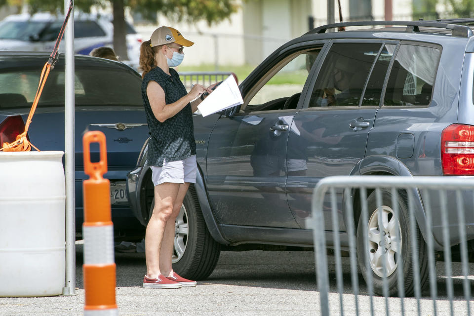 People line up at the Covid-19 testing site at LSU's Alex Box Stadium parking lot, Tuesday July 7, 2020, in Baton Rouge, La. (Bill Feig/The Advocate via AP)