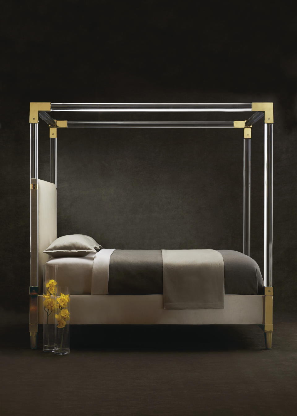 This undated photo provided by Bernhardt Furniture Company shows a gold and acrylic bed. The bed features a plated brass frame, fine acrylic posts and is shown upholstered in an ivory plain cloth. (Stacey Van Berkel/Bernhardt Furniture Company via AP)