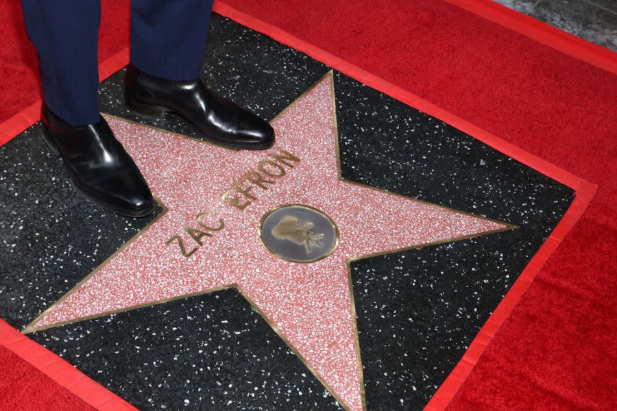 US actor Zac Efron stands on his newly unveiled star during his Hollywood Walk of Fame ceremony in Hollywood, California, on December 11, 2023. (Photo by TOMMASO BODDI / AFP) (Photo by TOMMASO BODDI/AFP via Getty Images)