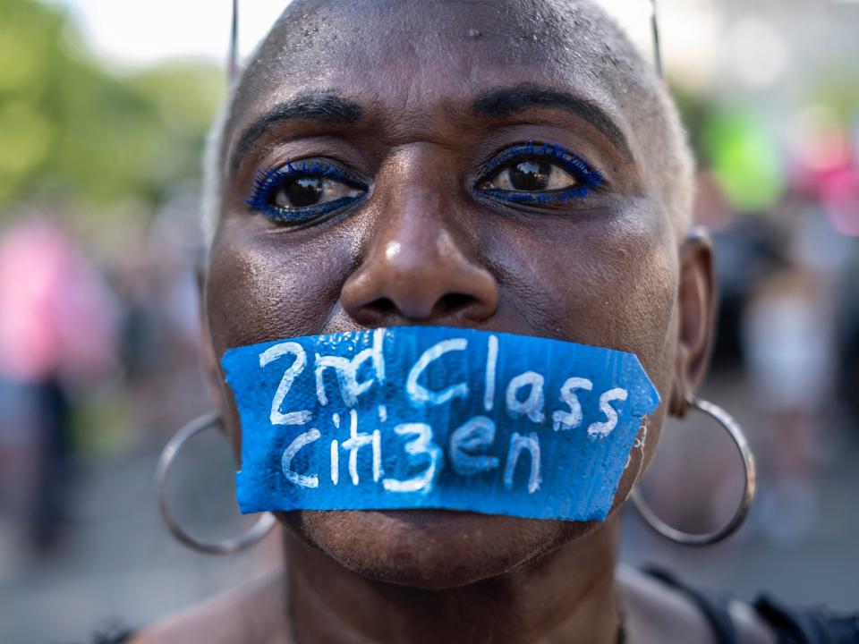 Abortion rights activist wears tape on her mouth with the words "Second Class Citizen" while protesting in front of the Supreme Court building following the announcement to the Dobbs v Jackson Women's Health Organization ruling