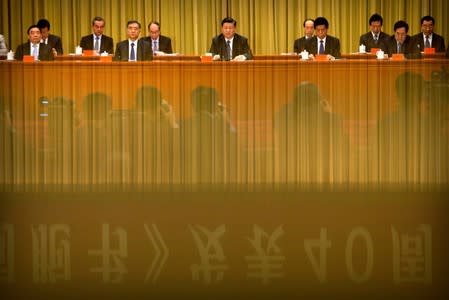 A banner is reflected on a polished surface as Chinese President Xi Jinping (C) speaks during an event to commemorate the 40th anniversary of the "Message to Compatriots in Taiwan" at the Great Hall of the People in Beijing