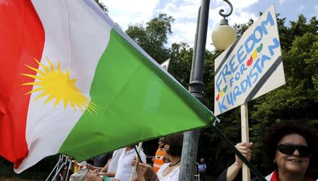 A woman holds a placard during a demonstration against the Turkish army operations against Kurdish militants, near the Turkish embassy in Berlin, Germany, August 5, 2015. REUTERS/Fabrizio Bensch