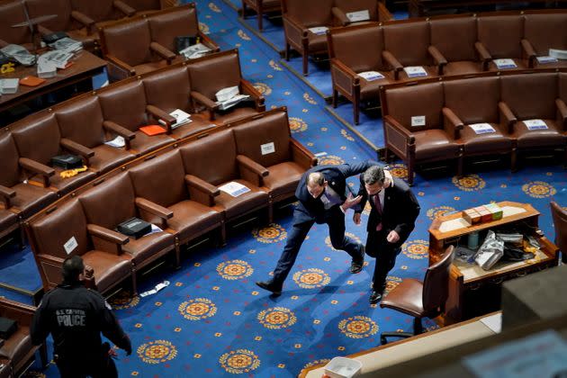 A member of the U.S. Capitol Police rushes a lawmaker out of the House Chamber as rioters try to enter the floor and obstruct the certification of Joe Biden's 2020 presidential win. (Photo: Drew Angerer via Getty Images)