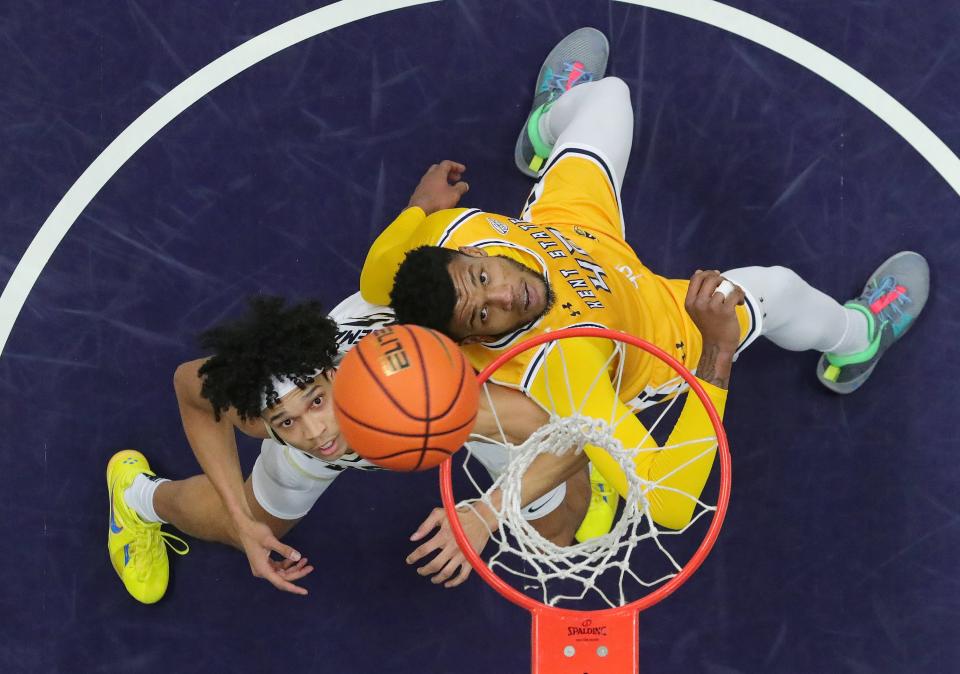 Akron Zips forward Enrique Freeman, left, eyes down the ball against Kent State center Cli'Ron Hornbeak in the first half, Friday, Feb. 23, 2024.