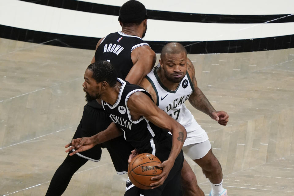 Milwaukee Bucks' P.J. Tucker (17) fights through a pick set by Brooklyn Nets' Bruce Brown, top left, to defend against Kevin Durant, bottom left, during the first half of Game 7 of a second-round NBA basketball playoff series Saturday, June 19, 2021, in New York. (AP Photo/Frank Franklin II)