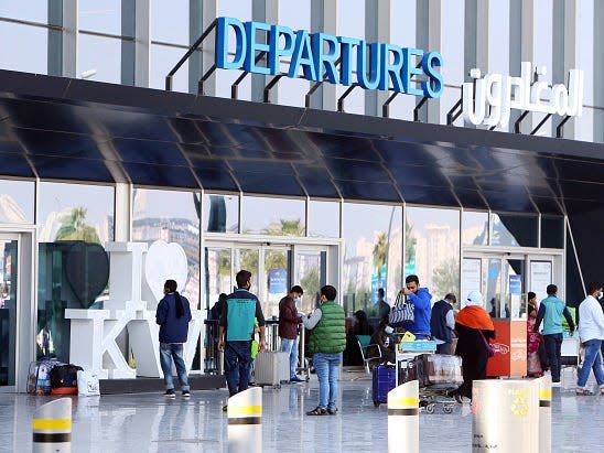 Passengers wait at the departure gate at Kuwait international airport in Kuwait City on January 2021.