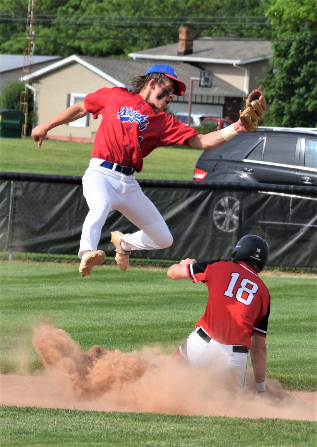 West Holmes sophomore shortstop Hunter Aurand leaps to haul in a throw trying to catch Gaven Blake stealing second in the first inning.