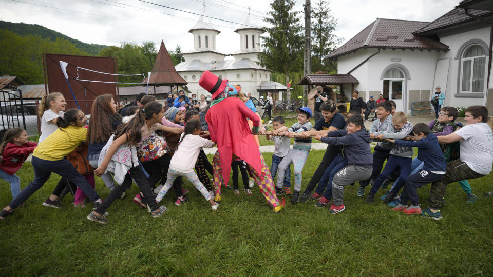 Children play during an eyesight examination performed by volunteer ophthalmologists, in Nucsoara, Romania, Saturday, May 29, 2021. Dozens of disadvantaged young Romanian children got a chance to get their eyesight examined for the first time in their lives during an event arranged by humanitarian organization Casa Buna, or Good House, which has played a prominent role in supporting the local children's lives throughout the pandemic. (AP Photo/Vadim Ghirda)