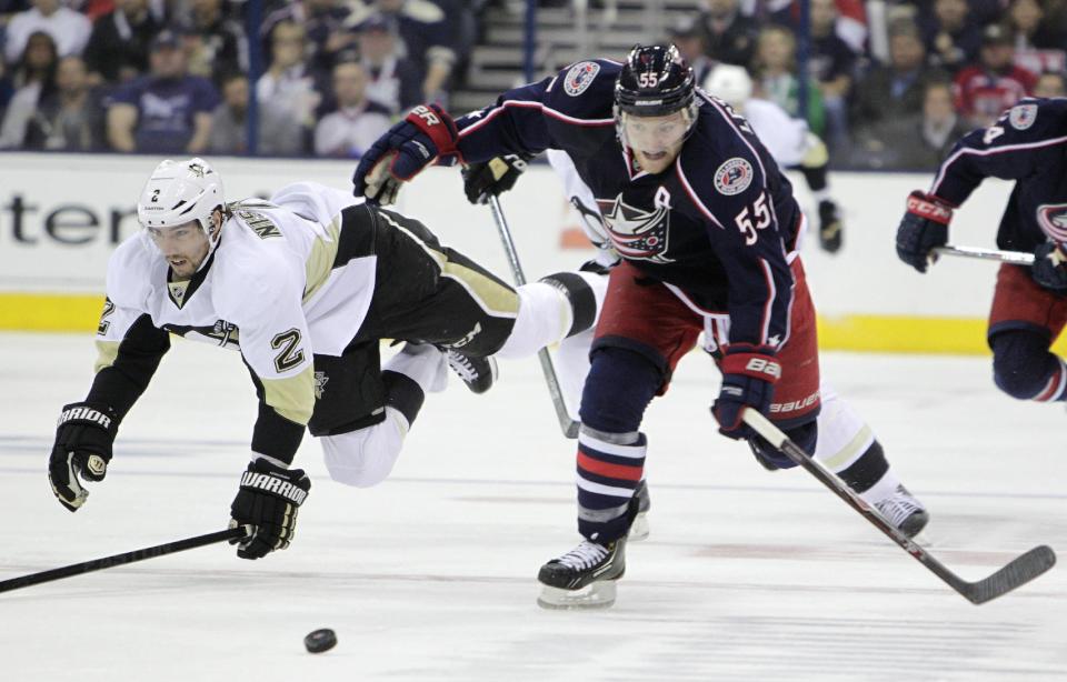 Columbus Blue Jackets' Mark Letestu, right, chases a loose puck as Pittsburgh Penguins' Matt Niskanen falls to the ice during the second period of Game 4 of a first-round NHL hockey playoff series on Wednesday, April 23, 2014, in Columbus, Ohio. (AP Photo/Jay LaPrete)