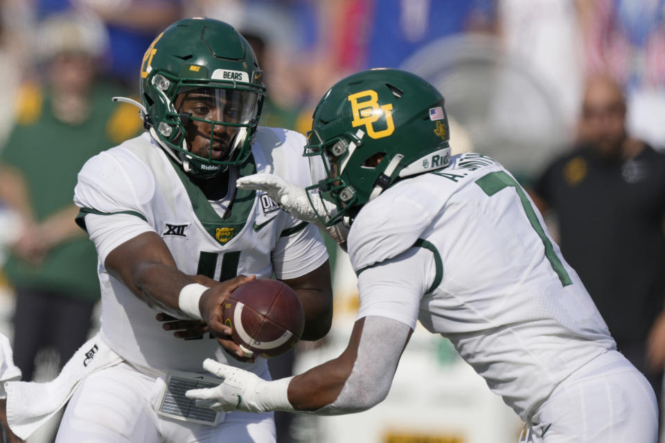 Baylor quarterback Gerry Bohanon (11) hands the ball to running back Abram Smith (7) during the second half of an NCAA college football game against Kansas in Lawrence, Kan., Saturday, Sept. 18 2021. Baylor defeated Kansas 45-7. (AP Photo/Orlin Wagner)