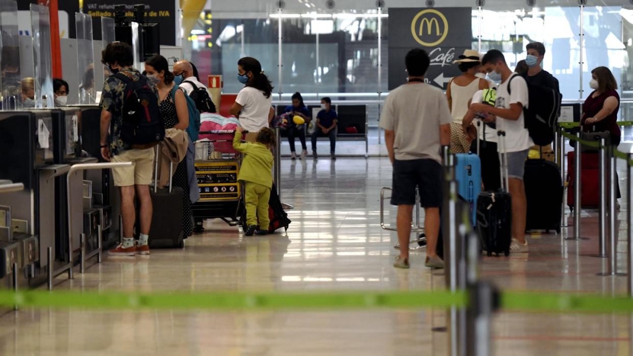 Reisende stehen an den Check-in-Schaltern im Terminal T1 des Flughafens in Madrid.