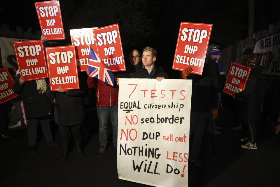 Loyalists protest outside the grounds were the Democratic Unionist Party executive meeting is taking place at Larchfield Estate in Lisburn, Northern Ireland, Monday, Jan. 29, 2024. The Unionist leader is meeting with his executive members to work on a deal to restore power-sharing at Stormont on Monday. The 130 strong-party executive was invited at short notice Monday to a secure venue as it is expected to be picked by Loyalist protesters opposed to returning to power. (AP Photo/Peter Morrison)