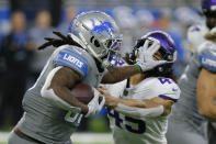 Detroit Lions running back Jamaal Williams (30) stiff arms Minnesota Vikings linebacker Troy Dye (45) during the first half of an NFL football game, Sunday, Dec. 5, 2021, in Detroit. (AP Photo/Duane Burleson)