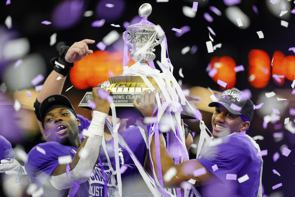FILE -Washington linebacker Edefuan Ulofoshio (5), on the left, and quarterback Michael Penix Jr. (9), on the right, celebrate after defeating Texas during the Sugar Bowl CFP NCAA semifinal college football game, Monday, Jan. 1, 2024, in New Orleans. ESPN and the College Football Playoff have agreed to a six-year deal worth $1.3 billion annually that allows the network to keep exclusive rights to the 12-team playoff through the 2031 season, two people with knowledge of the agreement told The Associated Press, Tuesday, Feb. 13, 2024. (AP Photo/Jacob Kupferman, FGile)