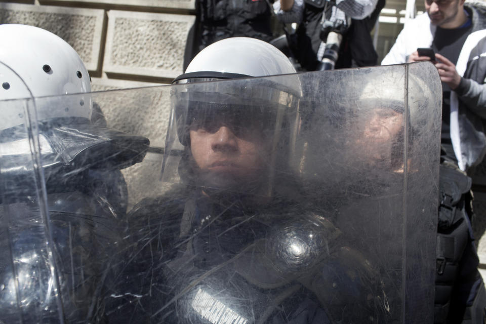 Riot police officers stand guard in front of the Serbian presidency building in Belgrade, Serbia, Sunday, March 17, 2019. As Serbian president Aleksandar Vucic held a news conference in the presidency building in downtown Belgrade, thousands of opposition supporters gathered in front demanding his resignation. Skirmishes with riot police were reported, including officers firing tear gas against the protesters who have pledged to form a human chain around the presidency to prevent Vucic from leaving the building. (AP Photo/Marko Drobnjakovic)