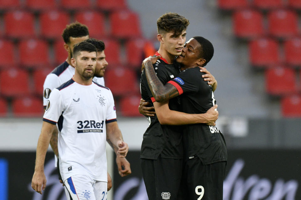 Leverkusen's Kai Havertz celebrates with Leon Bailey, right, at the end of the Europa League round of 16, second leg, soccer match between Bayer Leverkusen and Glasgow Rangers at the BayArena in Leverkusen, Germany, Thursday, Aug. 6, 2020. (Sascha Schuermann, Pool Photo via AP)