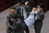 FILE - Pan-democratic legislator Ray Chan is taken away by security guards during a Legislative Council's House Committee meeting in Hong Kong on May 8, 2020. When the British handed its colony Hong Kong to Beijing in 1997, it was promised 50 years of self-government and freedoms of assembly, speech and press that are not allowed Chinese on the Communist-ruled mainland. As the city of 7.4 million people marks 25 years under Beijing's rule on Friday, those promises are wearing thin. Hong Kong's honeymoon period, when it carried on much as it always had, has passed, and its future remains uncertain, determined by forces beyond its control. (AP Photo/Kin Cheung, File)