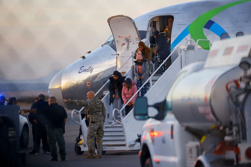 Migrants, transferred from Plattsburgh, New York, to El Paso, Texas, disembark from a plane at the airport, in El Paso