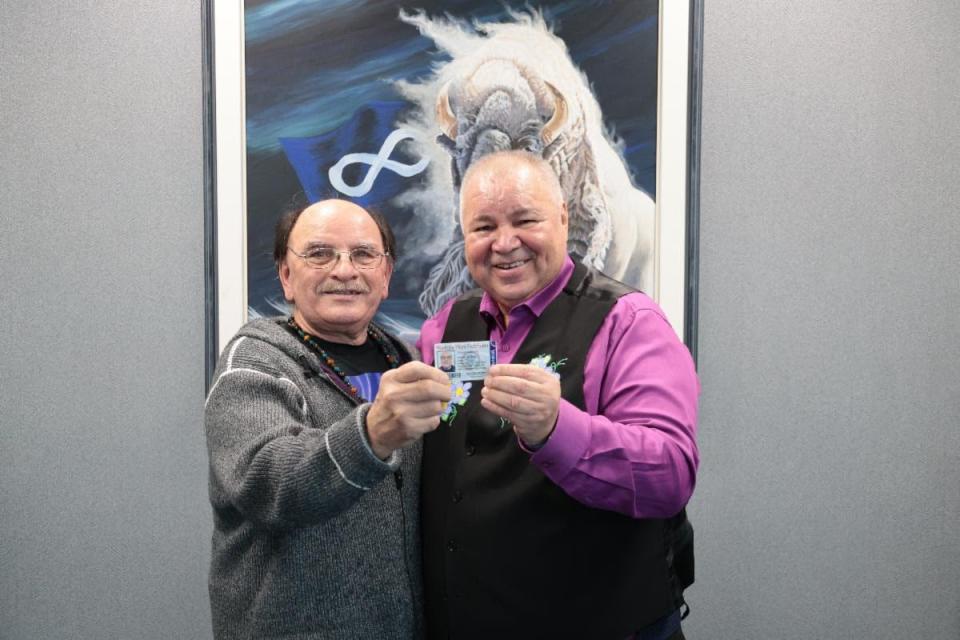 Edward Ambrose, left, and Manitoba Métis Federation president David Chartrand pose for a photo in February 2024 as Ambrose obtains his MMF citizenship card.