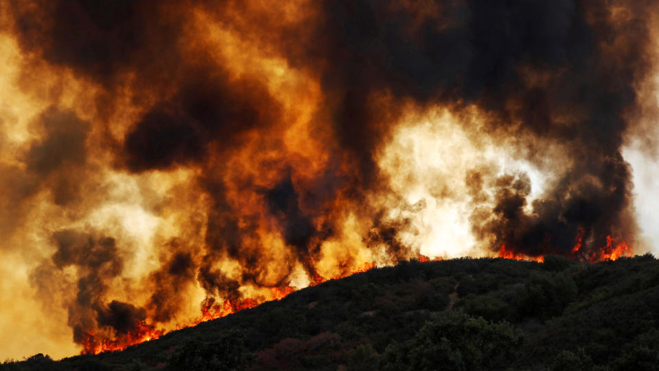 Wind-driven flames roll over a hill toward homes during the River fire near Lakeport, California, on Aug. 2. (Photo: Fred Greaves / Reuters)