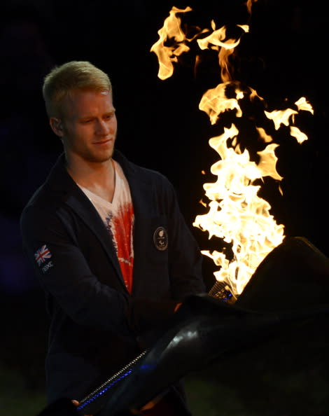 Britain's Paralympic sprinter Jonnie Peacock colllects the Paralympic Flame to extinguish it as the cauldron unwinds for the final time during the closing ceremony of the London 2012 Paralympic Games at the Olympic Stadium in east London on September 9, 2012. AFP PHOTO / ADRIAN DENNIS (Photo credit should read ADRIAN DENNIS/AFP/GettyImages)
