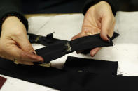 A woman shows a label inside the Borsalino hat factory in Spinetta Marengo, near Alessandria, Italy, Thursday, Jan. 17, 2019. Borsalino's prized felt hats are handmade by 80 workers in its Piemonte factory, many who have worked there for decades, with original machinery that use hot water and steam to transform rabbit fur into highly prized felt, that is formed into clochards, dyed and molded by hand to create the latest styles. (AP Photo/Antonio Calanni)