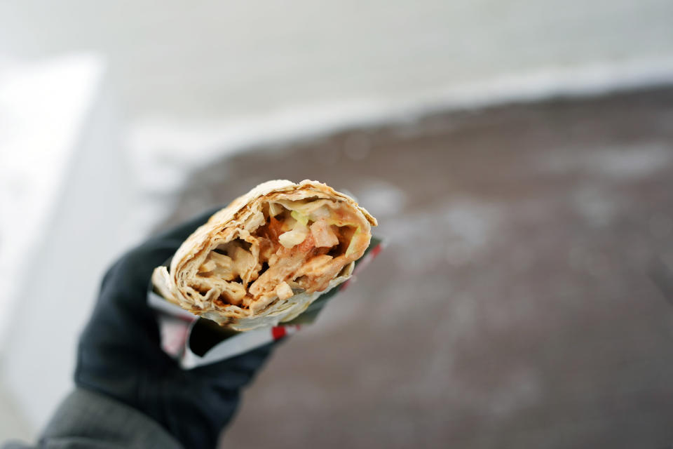 Gloved hand holding burrito