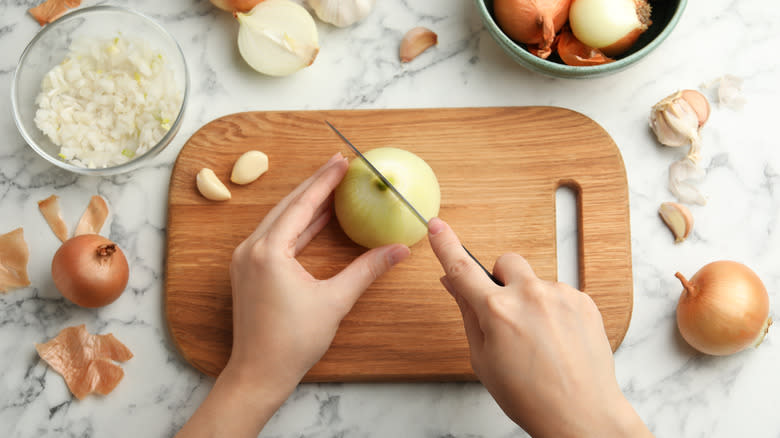 cutting white onions wooden board