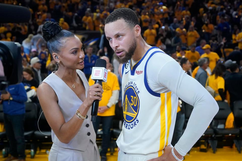ESPN reporter Malika Andrews, left, interviews Golden State Warriors guard Stephen Curry after Game 4 in the first round of the NBA playoffs.
