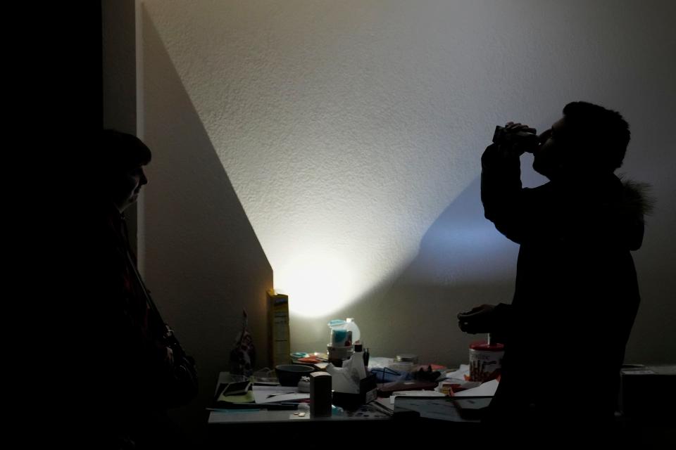 Amelia Valentin, left, watches as her husband, Jarod, drinks a protein shake inside their apartment after an earthquake in Rio Dell, Calif., Tuesday, Dec. 20, 2022. A strong earthquake shook a rural stretch of Northern California early Tuesday, jolting residents awake, cutting off power to thousands of people, and damaging some buildings and a roadway, officials said. (AP Photo/Godofredo A. Vásquez)