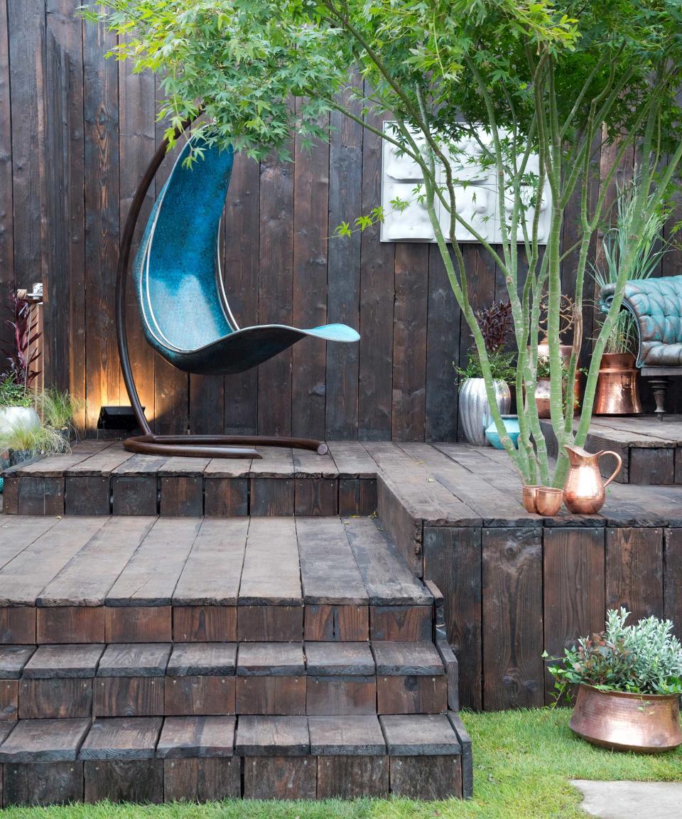 <p> If you're contemplating decking ideas for your garden, you could consider going one step further and extending it to a surrounding fence, just like in this scene. </p> <p> The result is a very modern 'garden room' that will feel sheltered and private – the perfect base for some statement outdoor furniture.  </p> <p> Add splashes of color with a selection of planters, or even an integrated tree for something a little more unusual. We love the sculptural shape of this acer and how it offers contrasting texture and vibrancy to its surroundings: a great example of landscaping with trees. </p>