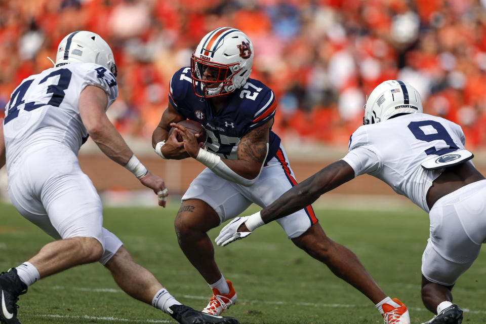 Auburn running back Jarquez Hunter (27) carries the ball as Penn State linebacker Tyler Elsdon (43) and cornerback Joey Porter Jr. (9) defend during the first half of an NCAA college football game, Saturday, Sept. 17, 2022, in Auburn, Ala. (AP Photo/Butch Dill)