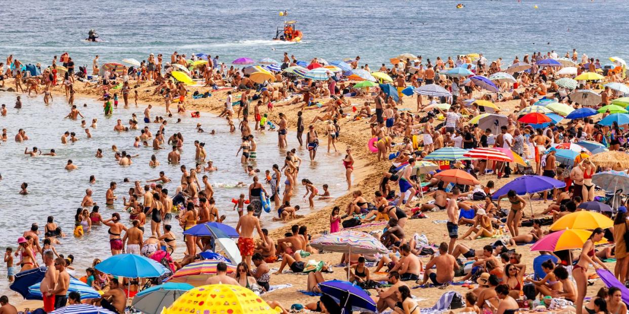 crowds of tourist on barceloneta beach, barcelona, spain